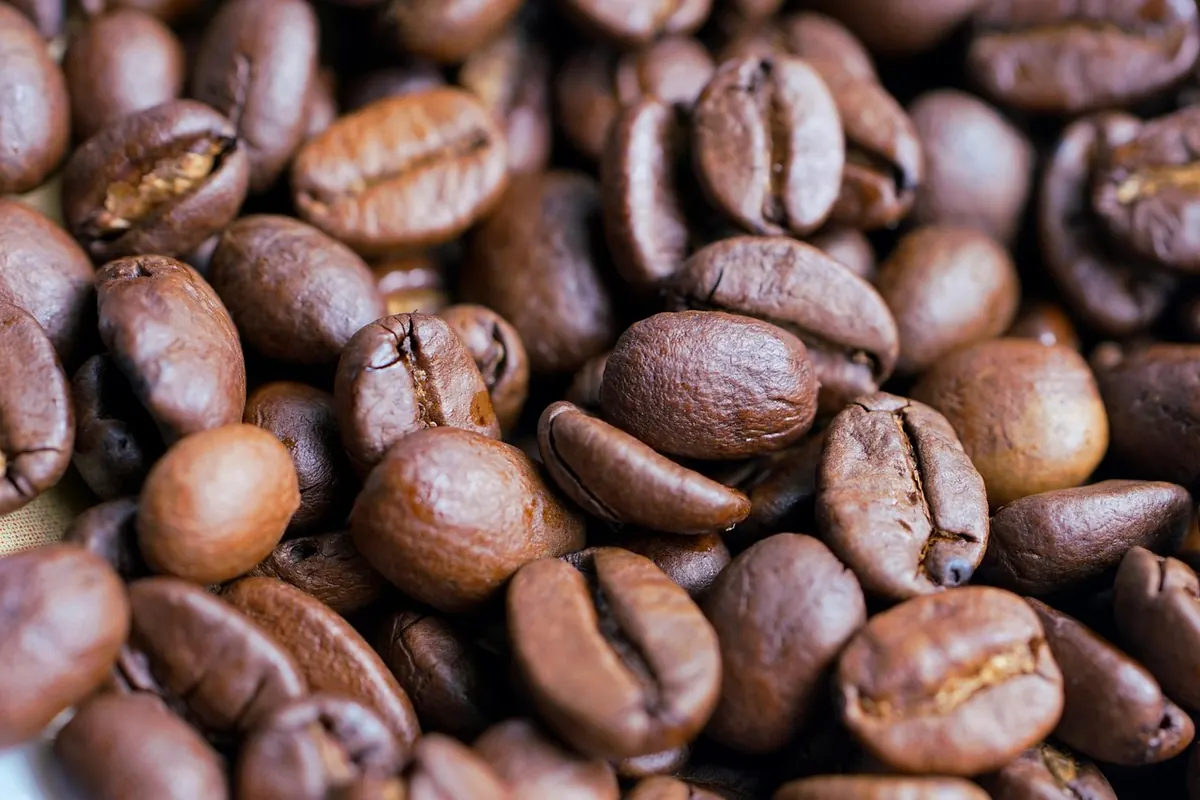 Granos de café tostados a montón, vistos de cerca