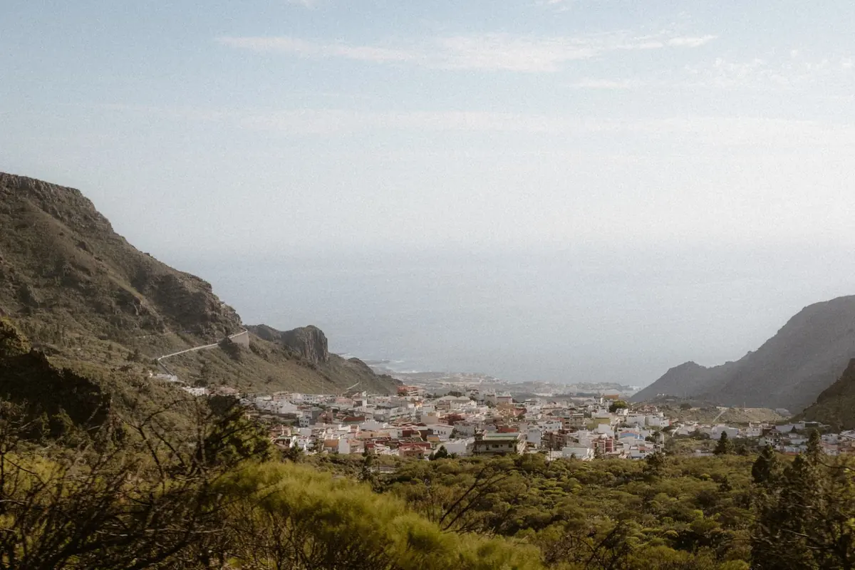 Pueblo de casas blancas al pie de los montes en Tenerife, con el mar al fondo
