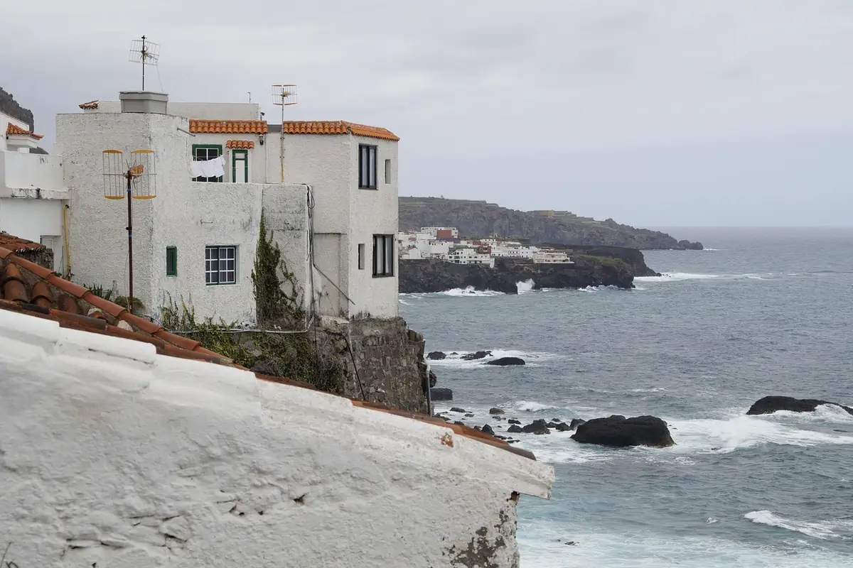 Casas blancas con tejado de teja junto al mar en un pueblo de costa de Tenerife
