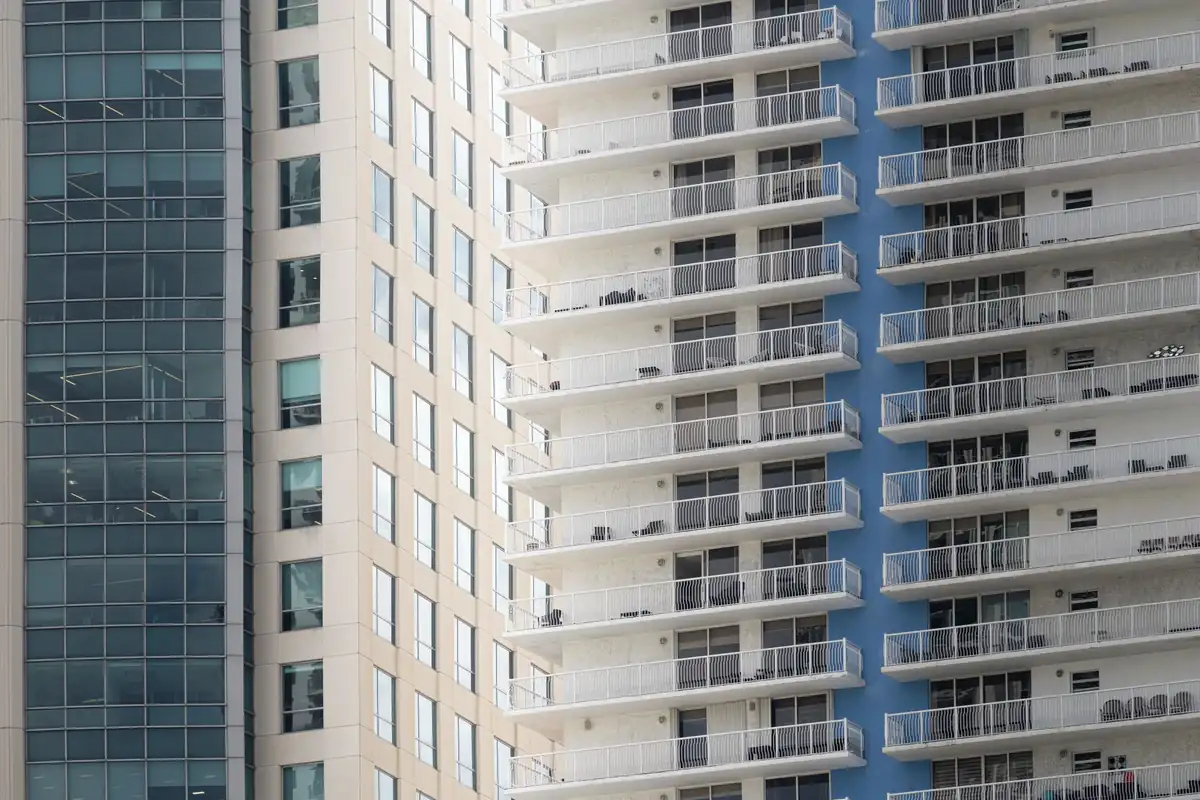 Fachadas de edificios altos con balcones de barandilla blanca