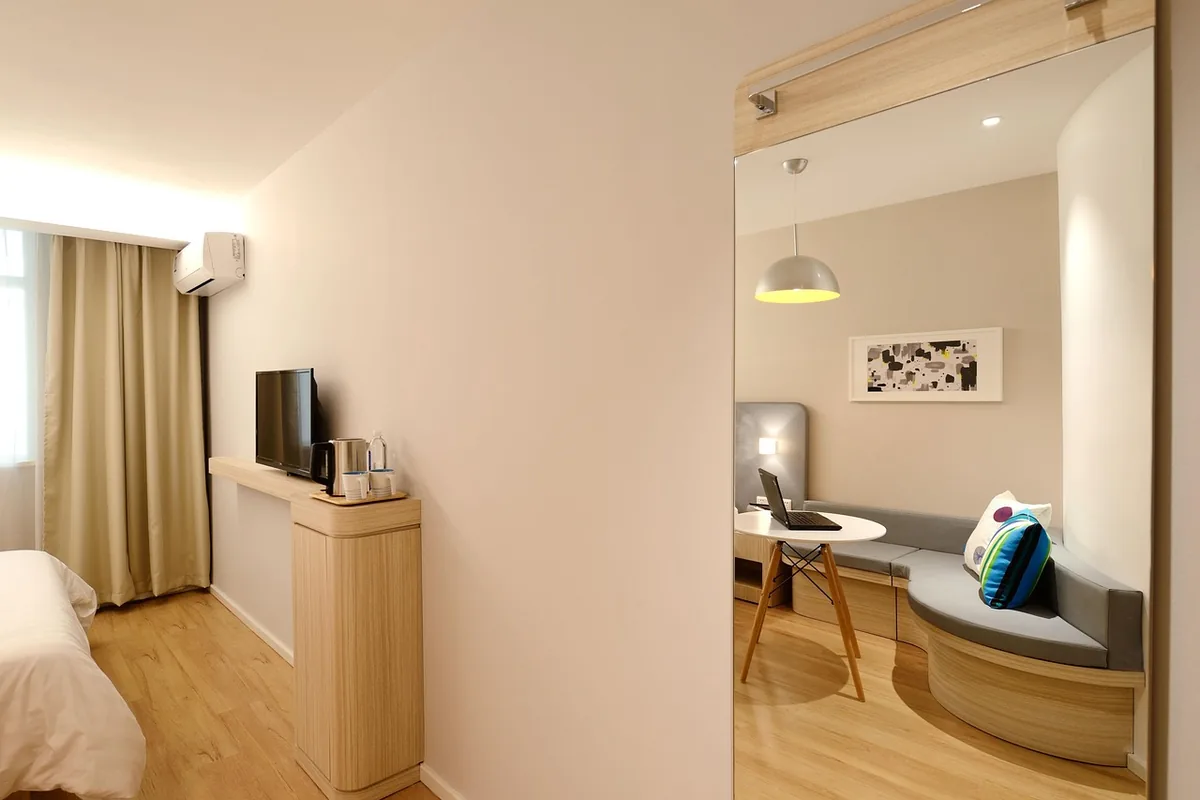 Habitación con un aire acondicionado de pared blanco junto a las cortinas