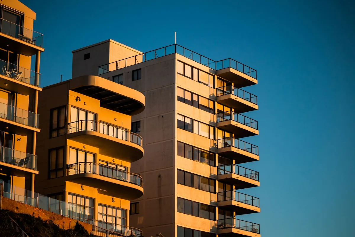Edificio de apartamentos con balcones de cristal al sol del atardecer