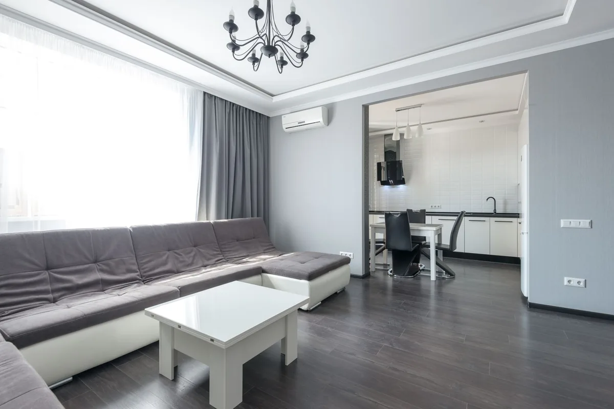 Salón con sofá y un aparato de aire acondicionado de pared junto a la ventana