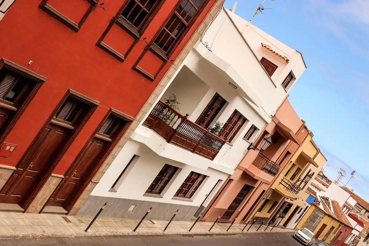 Casas de colores con balcones y contraventanas de madera en una calle de un pueblo de Canarias