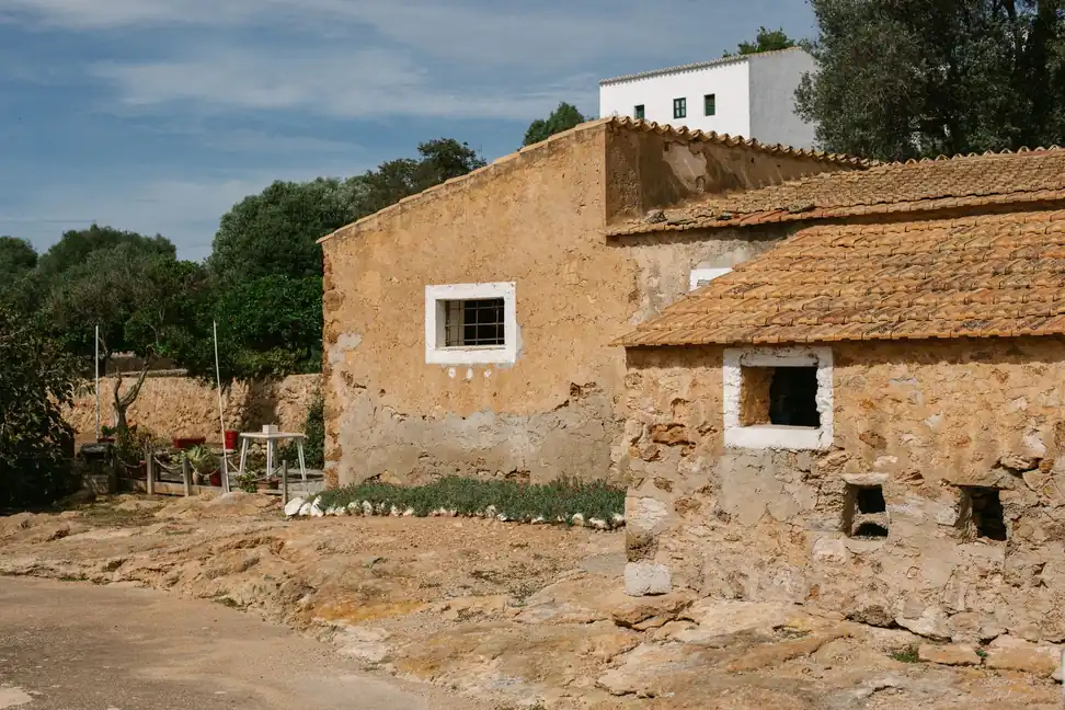 Casa rústica de piedra con muros gruesos, ventanas pequeñas y tejado de teja