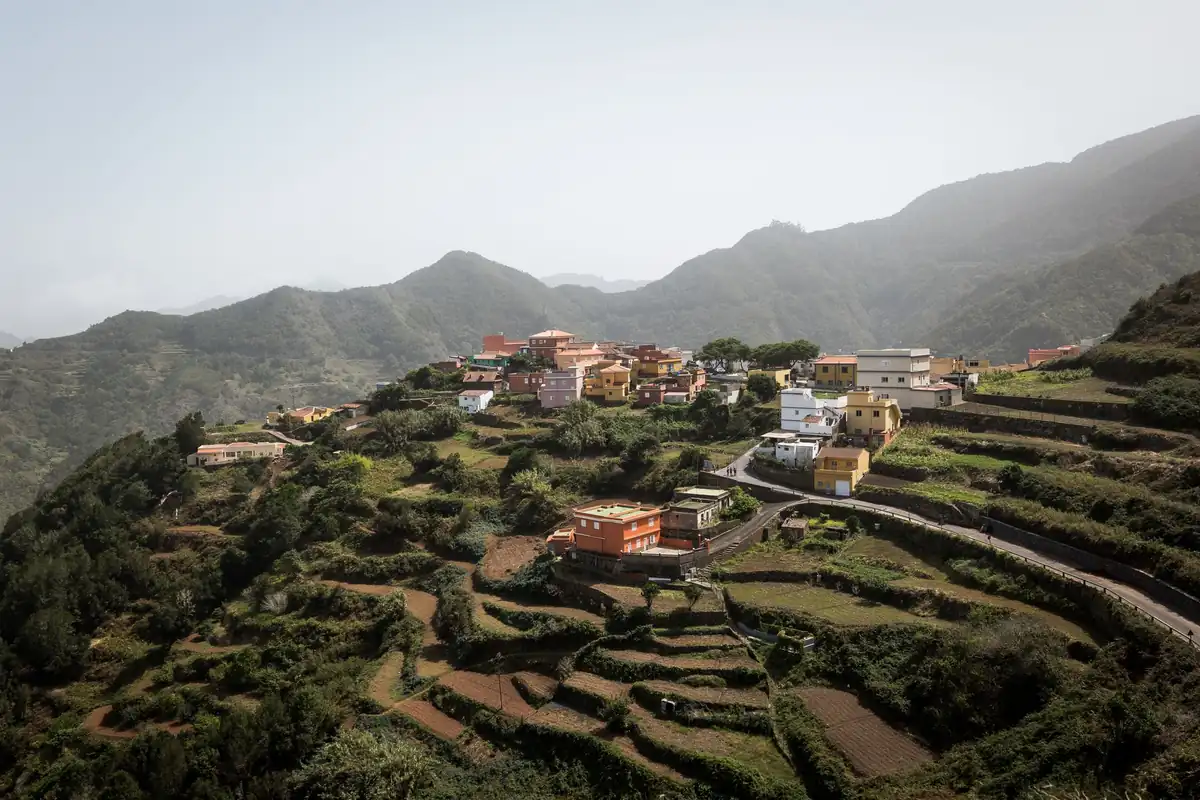 Casas de colores entre bancales verdes en una ladera de montaña de Tenerife