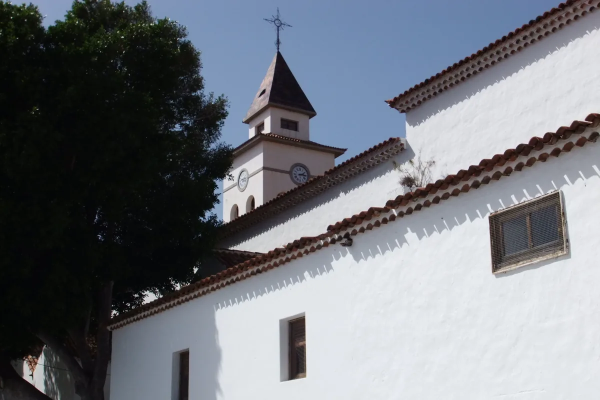 Muro blanco, tejas y torre con reloj de la iglesia de San Miguel Arcángel, en San Miguel de Abona