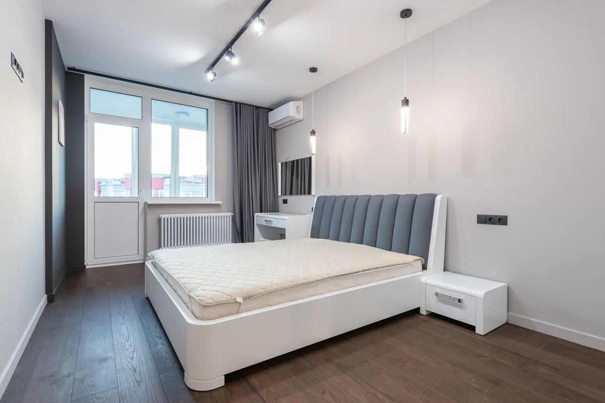 Dormitorio con una unidad interior blanca de aire acondicionado en la pared