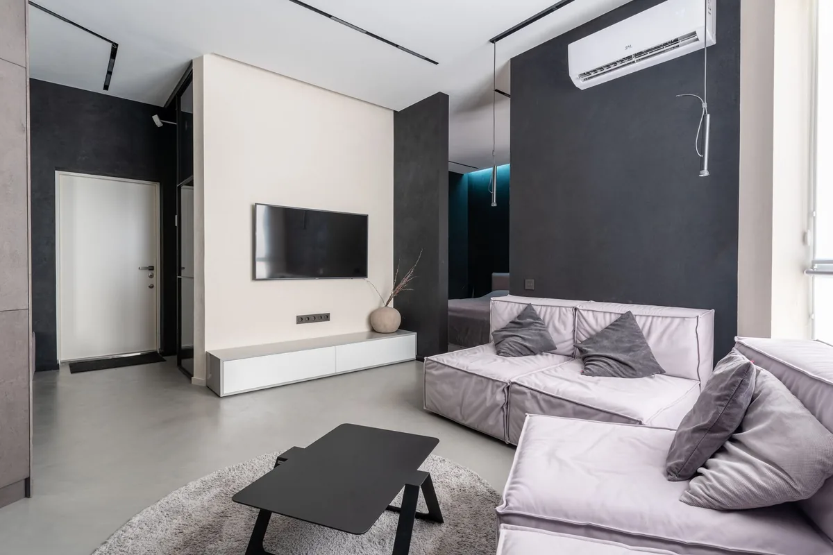 Salón moderno con una unidad interior de aire acondicionado en la pared, sobre un sofá