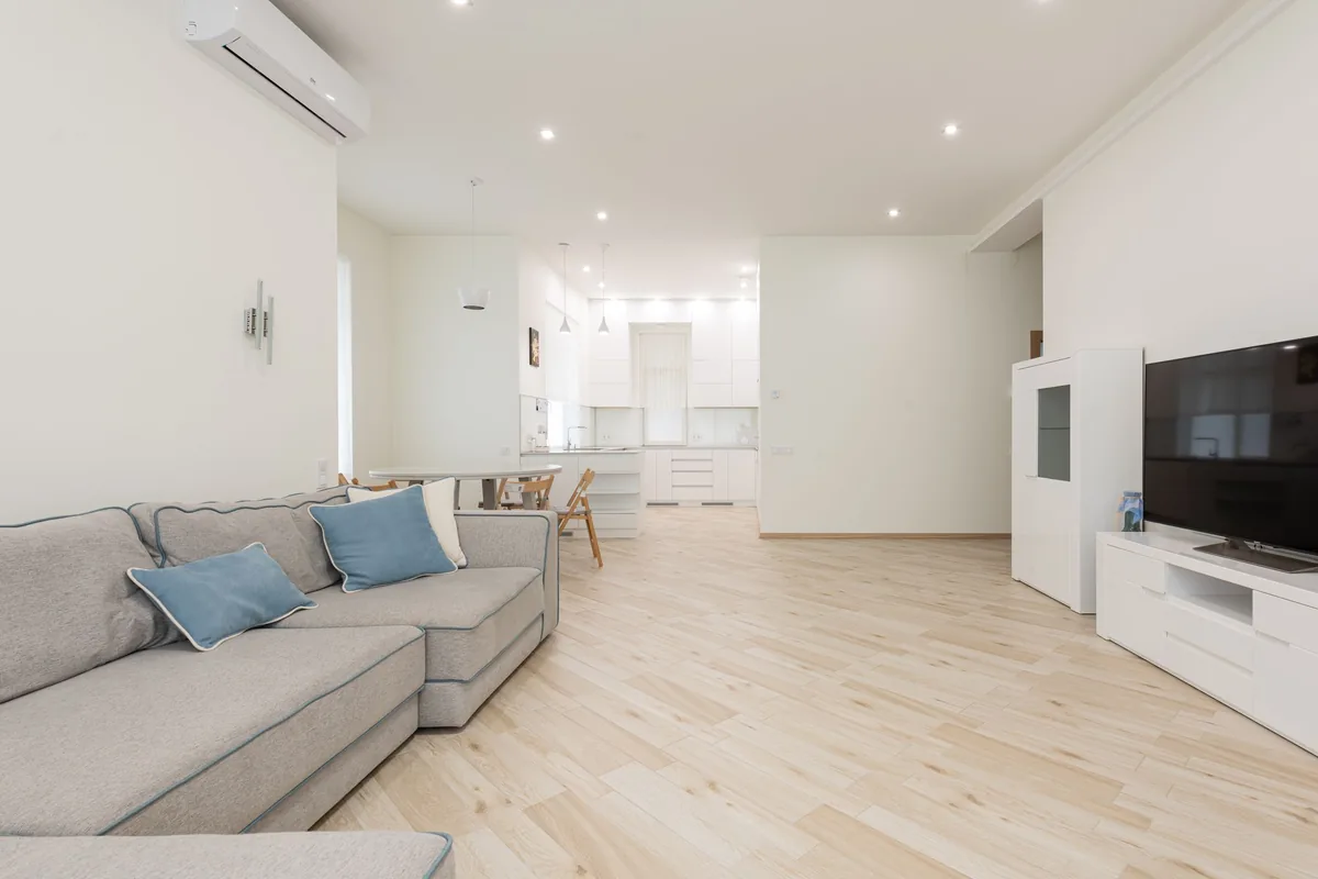 Salón amplio con cocina abierta y un split de pared junto al techo