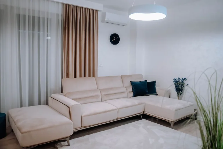 Split de aire acondicionado moderno instalado en la pared de un salón con sofá claro