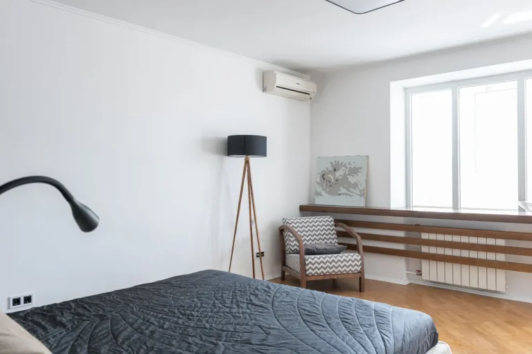 Split de aire acondicionado instalado en la pared de un dormitorio luminoso de una vivienda